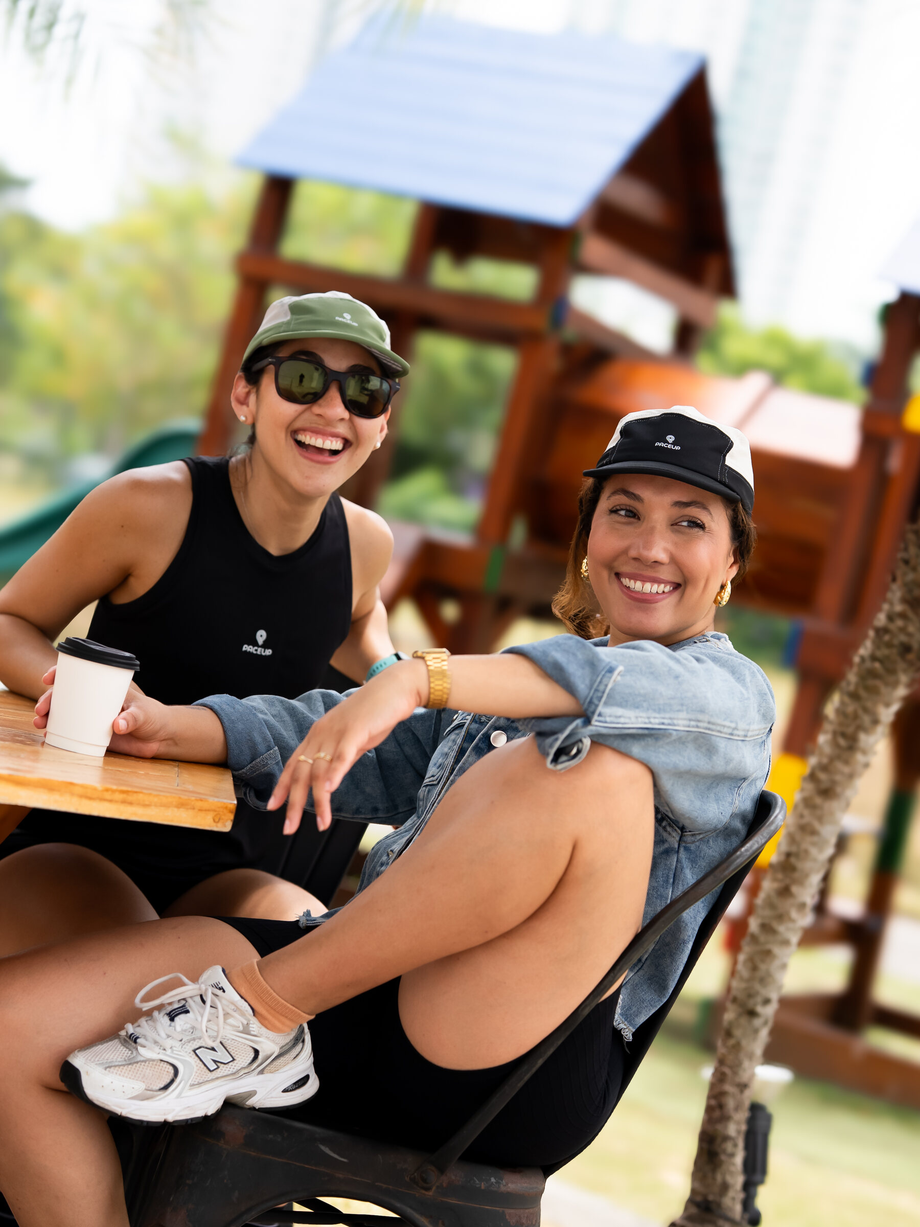 Dos corredoras con gorras Paceup tomando café después de entrenar